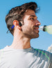 Man drinking water while wearing OPN Sound Mezzo+ headphones