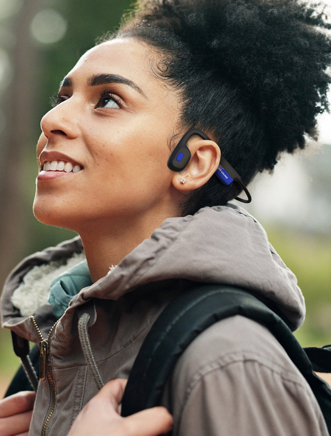 Woman outdoors wearing OPN Sound Mezzo+ open-ear headphones