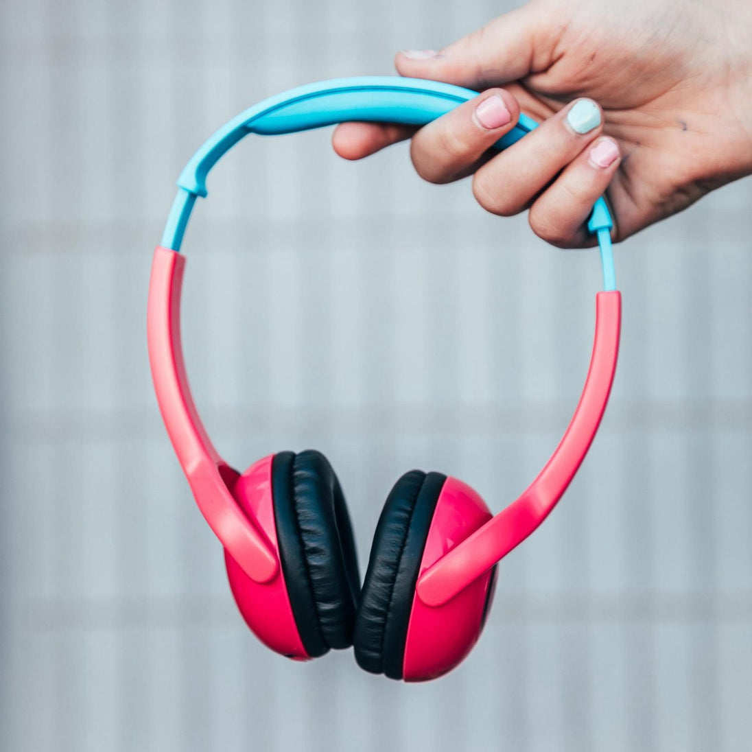 Wicked Audio Tricky Tike Candy Pink headphones held in hand