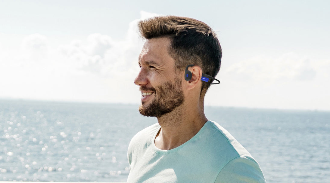 Man by the water wearing OPN Sound Mezzo+ headphones