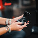 Wicked Audio Raen earbuds and charging case held in both hands