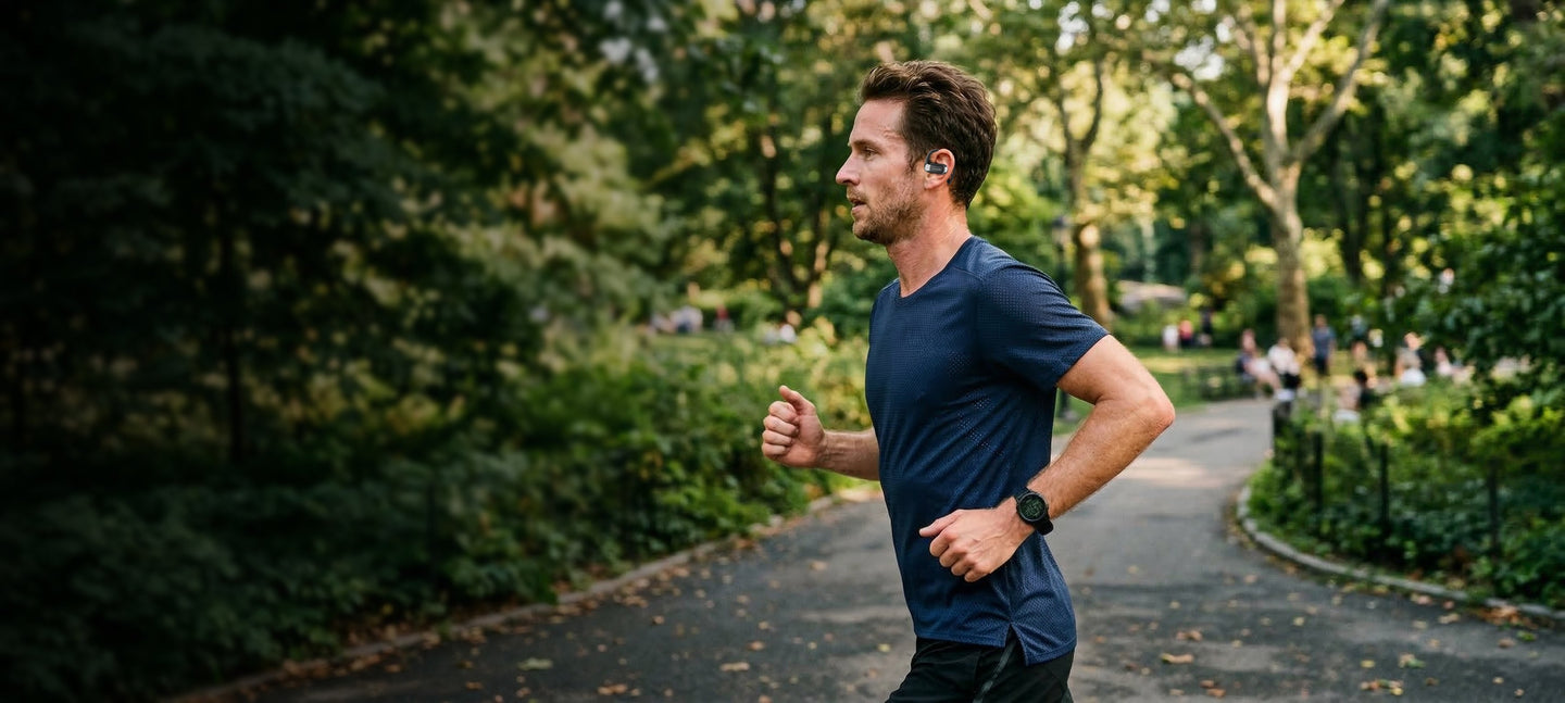 Runner in a park wearing OPN Sound Aria Pro headphones