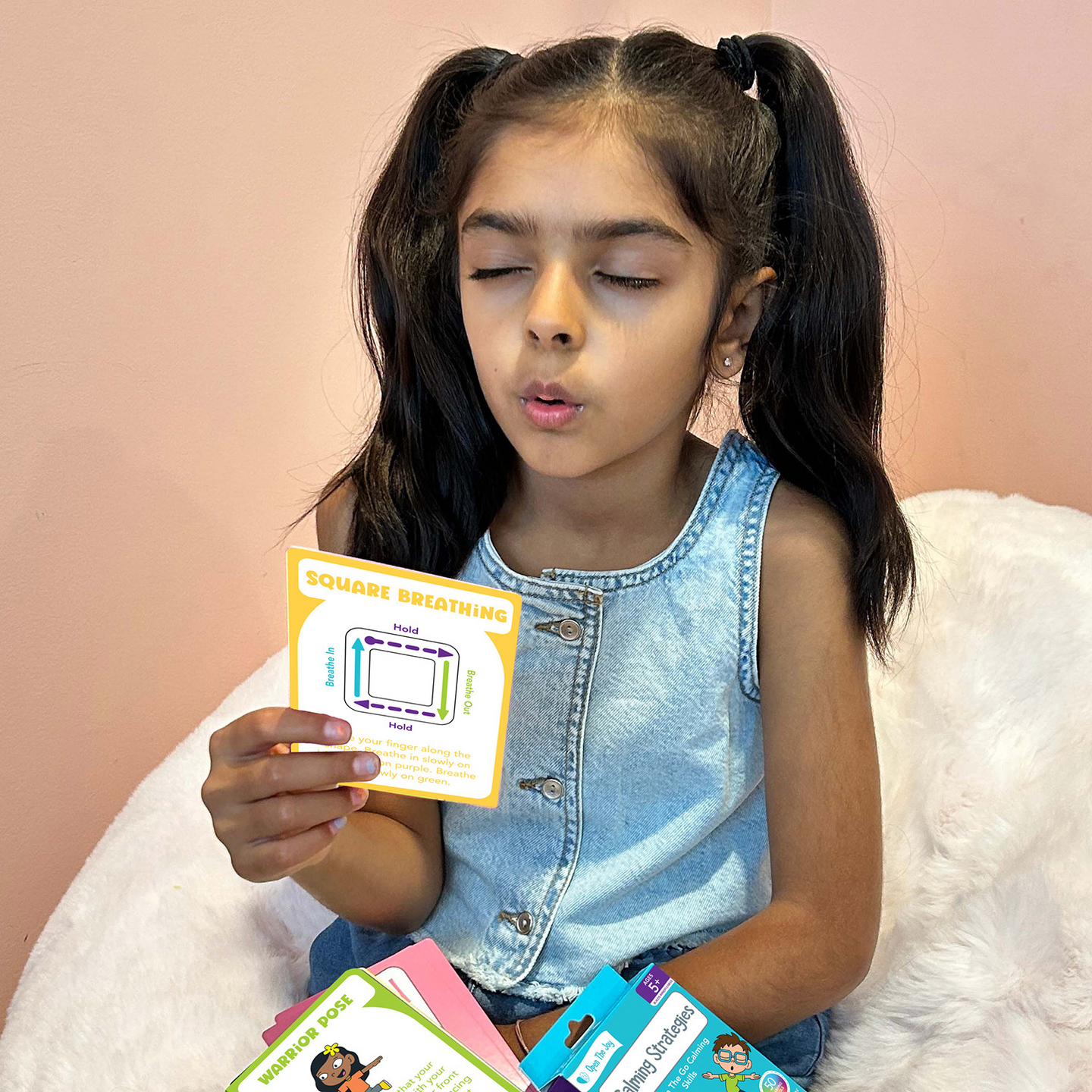 Girl holding up a Calming Strategies card