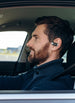 Man driving while wearing OPN Sound Aria Pro open-ear headphones