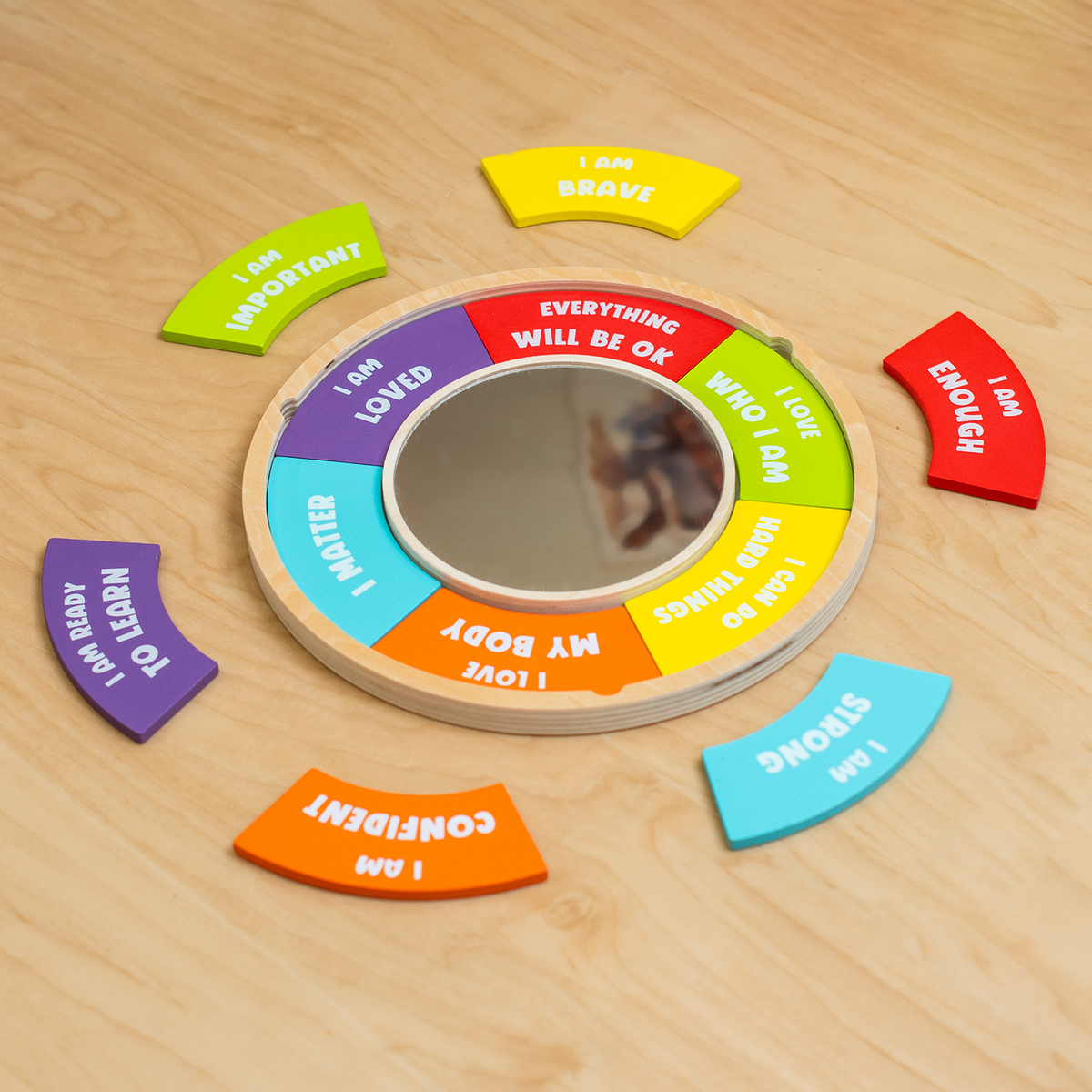 Confidence Building Mirror assembled with its affirmation petals on a wooden floor