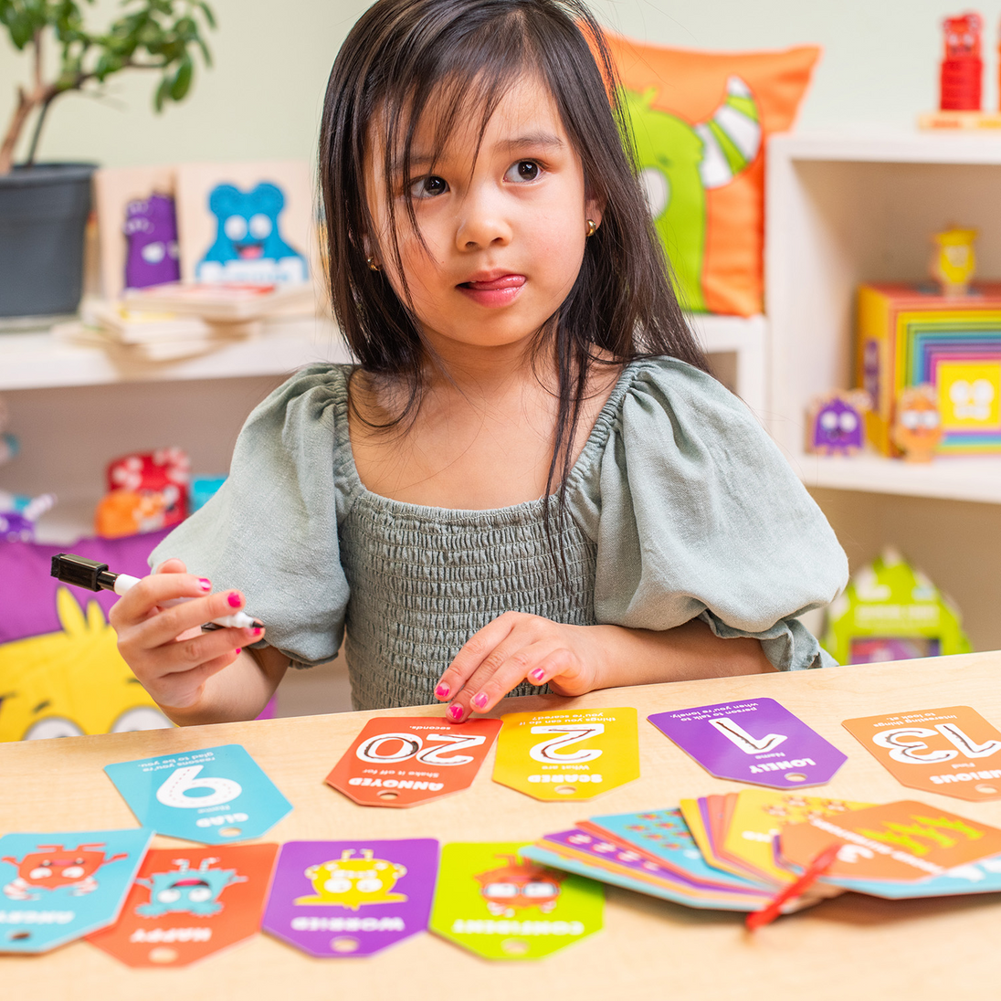 Young girl at a table using the Emotions 123's dry-erase cards