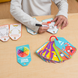 Hand writing on an Emotions ABC's dry-erase card with the deck fanned alongside