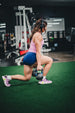 Woman training with a kettlebell while wearing Wicked Audio Hum 500x headphones