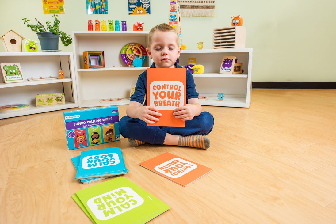 Child seated on a classroom floor with the Jumbo Calming Cards
