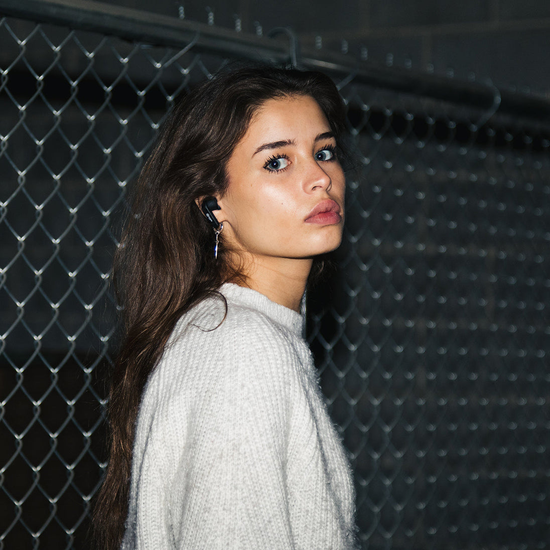 Woman wearing a Wicked Audio Mojo 800 earbud, side profile