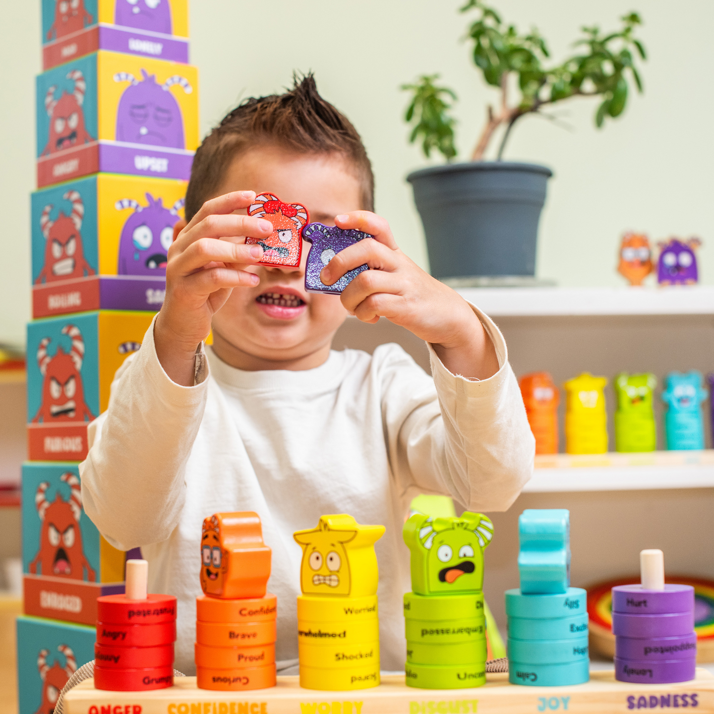Child holding two emotion stacking rings up to their eyes