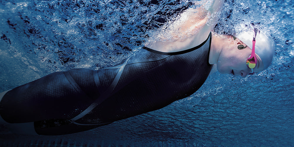 Swimmer wearing waterproof OPN Sound Swym+ headphones in a pool