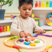 Toddler playing with the My Emotions Wheel puzzle at a table
