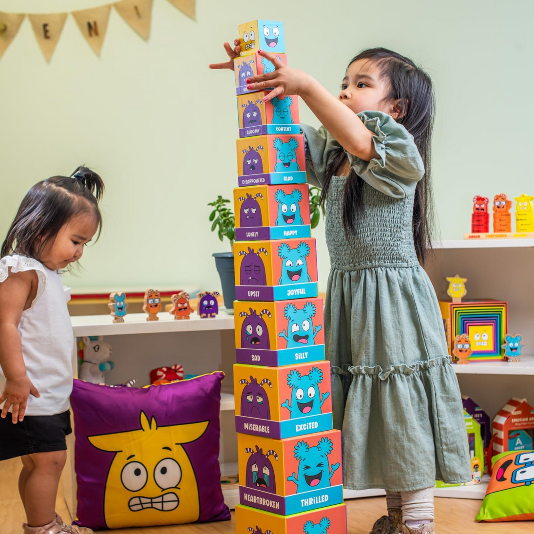 Two girls stacking the Tower of Emotions blocks