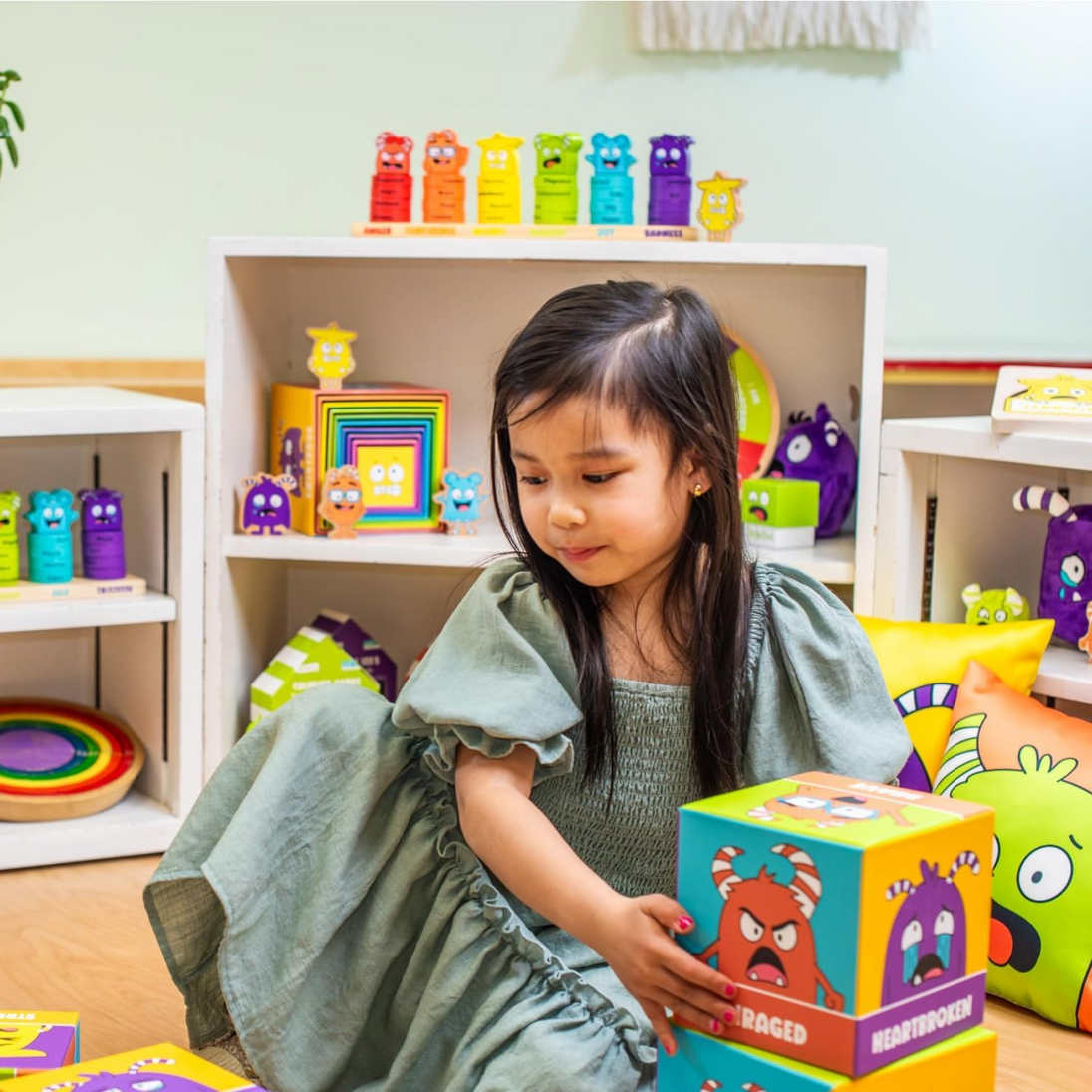 Girl playing with the Tower of Emotions blocks in a playroom